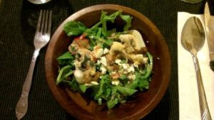 An arugala salad with duck skin cracklings and a duck fat vinegarette